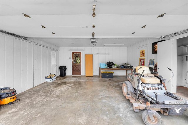 22117 E 1250th Rd, Rocky, OK 73661 - garage featuring a garage door opener and wood walls
