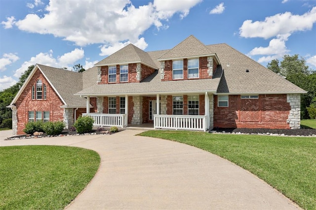 11409 SW 109th St, Mustang, OK 73064 - view of front facade featuring covered porch, brick siding, a front yard, and roof with shingles