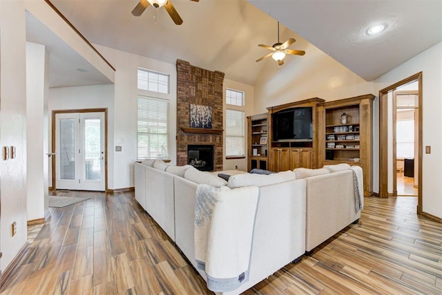 11409 SW 109th St, Mustang, OK 73064 - living room with a ceiling fan, a fireplace, light wood-type flooring, and high vaulted ceiling