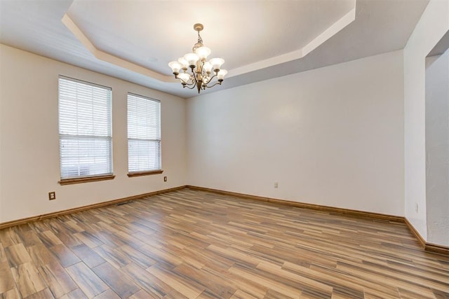 11409 SW 109th St, Mustang, OK 73064 - unfurnished room with a raised ceiling, a chandelier, and light wood-style flooring