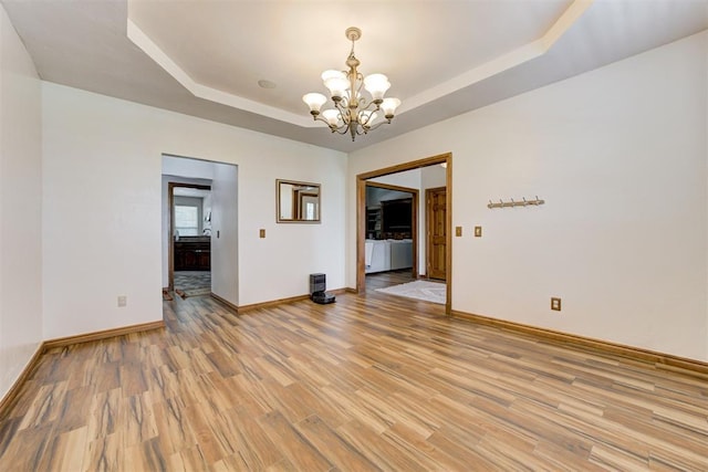 11409 SW 109th St, Mustang, OK 73064 - unfurnished room with a chandelier, a raised ceiling, and light wood-type flooring