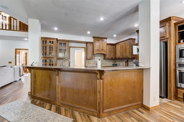 11409 SW 109th St, Mustang, OK 73064 - kitchen with a breakfast bar, light wood-type flooring, decorative backsplash, stainless steel appliances, and recessed lighting