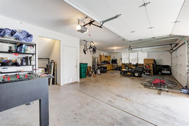 11409 SW 109th St, Mustang, OK 73064 - garage featuring a garage door opener and freestanding refrigerator