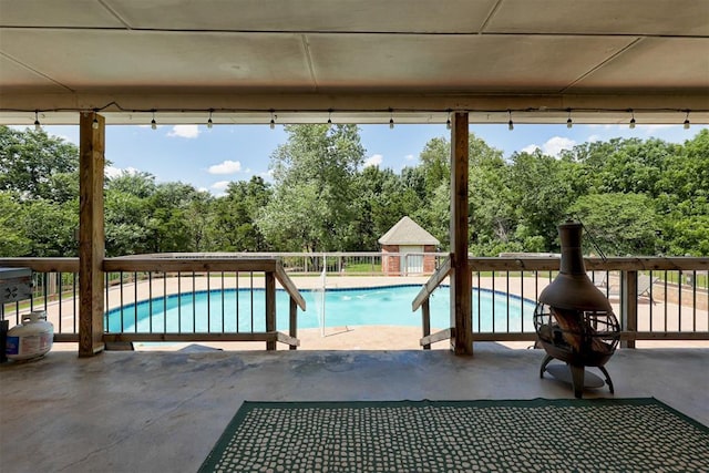 11409 SW 109th St, Mustang, OK 73064 - view of swimming pool with view of wooded area and a patio