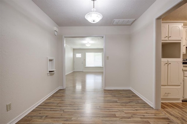 521 NW 50th St, Oklahoma City, OK 73118 - corridor with wood finished floors and a textured ceiling