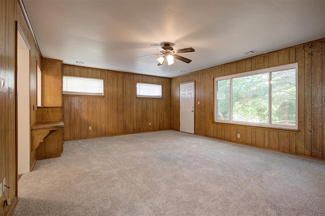521 NW 50th St, Oklahoma City, OK 73118 - unfurnished living room with ceiling fan, light colored carpet, and wood walls