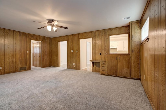 521 NW 50th St, Oklahoma City, OK 73118 - unfurnished bedroom with light carpet, wooden walls, and a ceiling fan