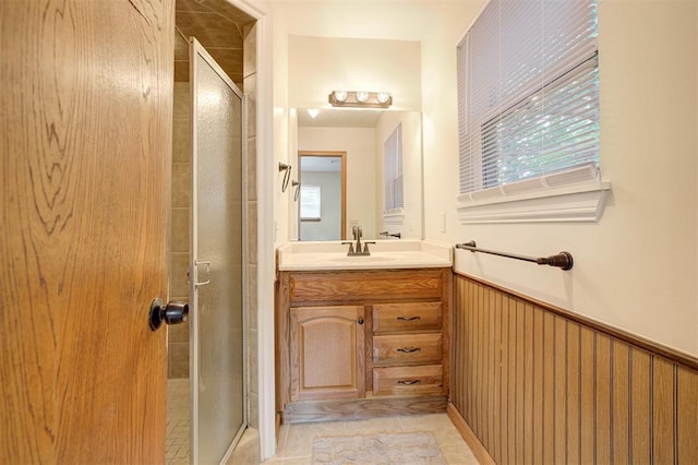 521 NW 50th St, Oklahoma City, OK 73118 - bathroom with a shower stall, vanity, a wainscoted wall, and tile patterned floors