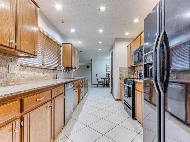 700 S Willowood Dr, Yukon, OK 73099 - kitchen with black appliances, light tile patterned flooring, decorative backsplash, recessed lighting, and light stone countertops