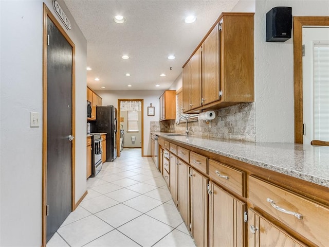 700 S Willowood Dr, Yukon, OK 73099 - kitchen featuring recessed lighting, black appliances, light stone countertops, tasteful backsplash, and light tile patterned flooring