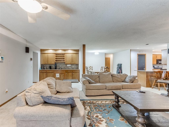 700 S Willowood Dr, Yukon, OK 73099 - living area featuring a textured ceiling, light carpet, bar, and a ceiling fan