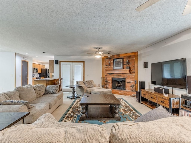 700 S Willowood Dr, Yukon, OK 73099 - living area featuring a ceiling fan, a textured ceiling, a fireplace, and light carpet