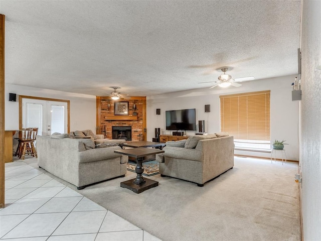 700 S Willowood Dr, Yukon, OK 73099 - living area with ceiling fan, a fireplace, a textured ceiling, and light tile patterned floors