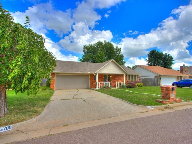 700 S Willowood Dr, Yukon, OK 73099 - single story home with an attached garage, concrete driveway, brick siding, and a porch
