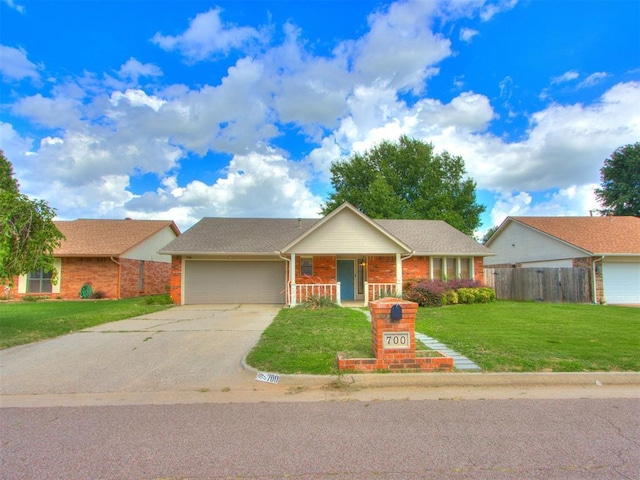 700 S Willowood Dr, Yukon, OK 73099 - single story home featuring an attached garage, brick siding, concrete driveway, and a porch