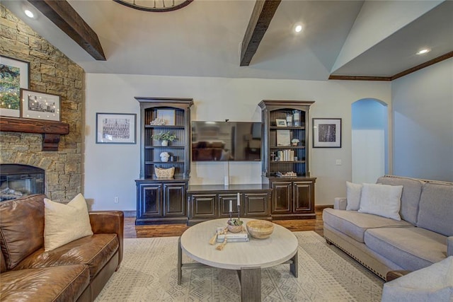 9020 NW 147th Ter, Yukon, OK 73099 - living room featuring wood finished floors, arched walkways, a stone fireplace, and recessed lighting