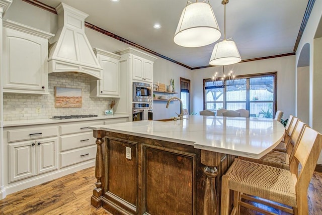 9020 NW 147th Ter, Yukon, OK 73099 - kitchen with stainless steel appliances, premium range hood, decorative backsplash, white cabinets, and light wood-style flooring