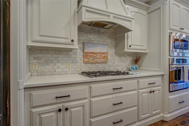 9020 NW 147th Ter, Yukon, OK 73099 - kitchen with stainless steel appliances, custom range hood, light countertops, and decorative backsplash