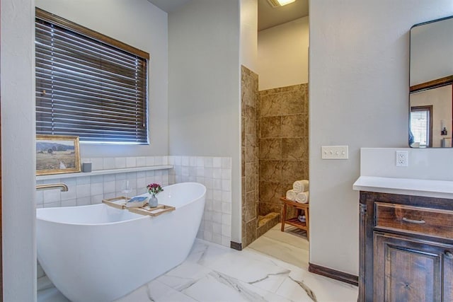 9020 NW 147th Ter, Yukon, OK 73099 - full bathroom featuring tile walls, a soaking tub, vanity, marble finish flooring, and wainscoting