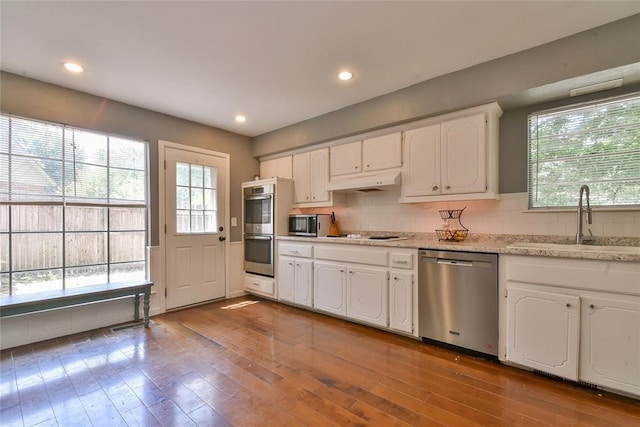 8800 Stoneleigh Ct, Oklahoma City, OK 73132 - kitchen with appliances with stainless steel finishes, white cabinetry, hardwood / wood-style floors, tasteful backsplash, and recessed lighting