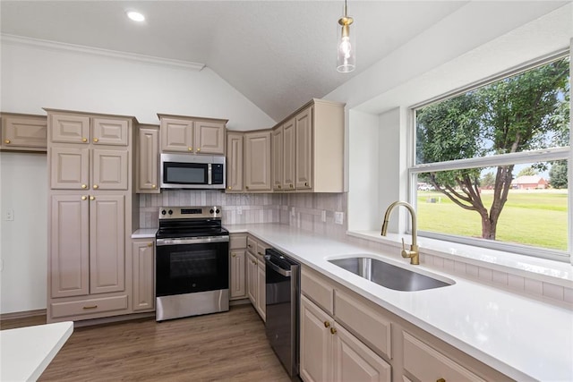 2719 NW 30th St, Newcastle, OK 73065 - kitchen featuring appliances with stainless steel finishes, lofted ceiling, light countertops, decorative backsplash, and decorative light fixtures