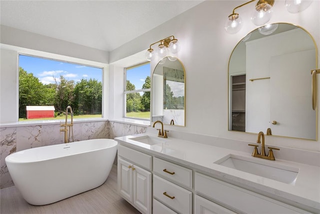2719 NW 30th St, Newcastle, OK 73065 - full bathroom with double vanity, a freestanding bath, tile walls, and wainscoting