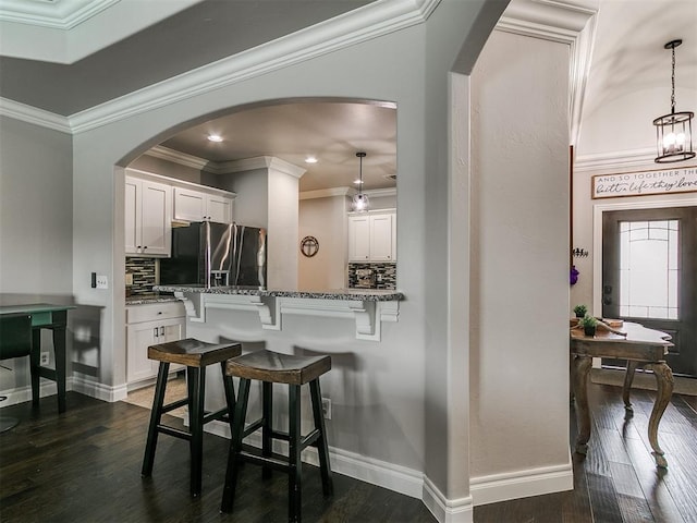 7032 NW 159th Pl, Edmond, OK 73013 - kitchen with refrigerator with ice dispenser, arched walkways, white cabinetry, ornamental molding, and recessed lighting