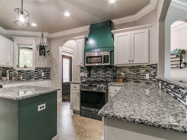 7032 NW 159th Pl, Edmond, OK 73013 - kitchen with appliances with stainless steel finishes, arched walkways, tasteful backsplash, crown molding, and light tile patterned flooring