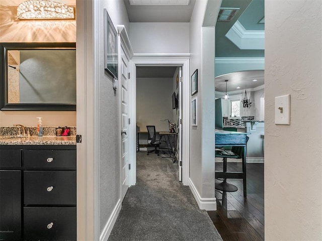 7032 NW 159th Pl, Edmond, OK 73013 - corridor featuring ornamental molding, an office area, arched walkways, dark wood-style flooring, and a textured wall
