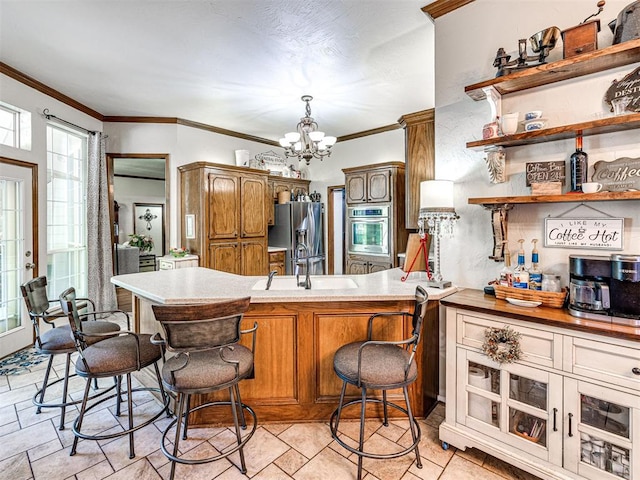 117 S Lexington Way, Edmond, OK 73012 - kitchen featuring stainless steel appliances, a chandelier, brown cabinets, a breakfast bar, and a peninsula