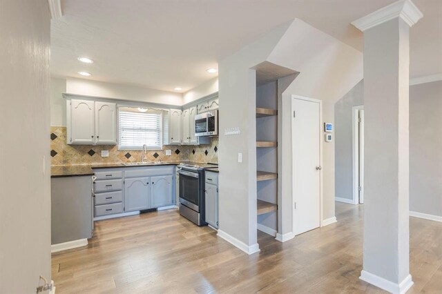 10900 Rock Ridge Rd, Oklahoma City, OK 73120 - kitchen with appliances with stainless steel finishes, tasteful backsplash, light wood-type flooring, dark countertops, and recessed lighting