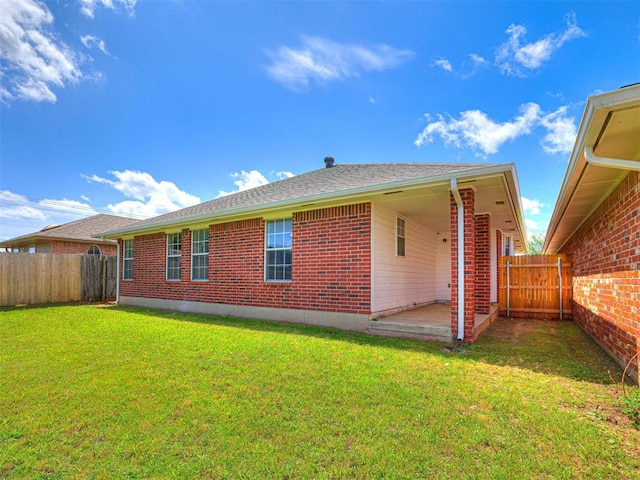4917 SE 89th Ter, Oklahoma City, OK 73135 - rear view of house with a fenced backyard, brick siding, and a patio