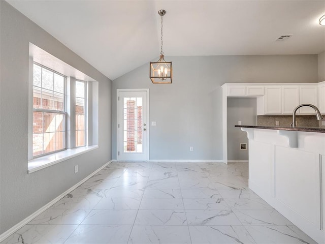 4917 SE 89th Ter, Oklahoma City, OK 73135 - unfurnished dining area featuring light marble finish floors, a chandelier, and lofted ceiling