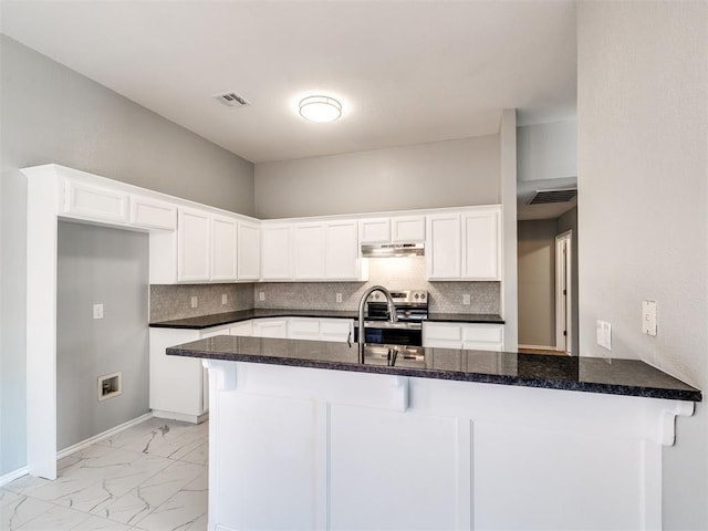 4917 SE 89th Ter, Oklahoma City, OK 73135 - kitchen with light marble finish flooring, stainless steel range with electric cooktop, decorative backsplash, and white cabinetry