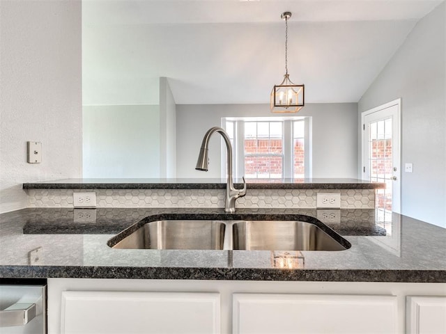 4917 SE 89th Ter, Oklahoma City, OK 73135 - kitchen with vaulted ceiling, white cabinetry, dark stone countertops, hanging light fixtures, and a chandelier