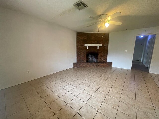 5333 Coble St, Oklahoma City, OK 73135 - unfurnished living room featuring light tile patterned floors, ceiling fan, a textured ceiling, and a fireplace