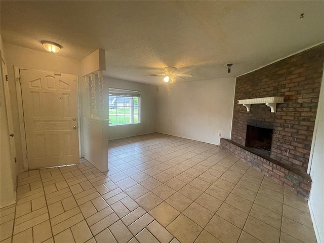 5333 Coble St, Oklahoma City, OK 73135 - unfurnished living room featuring ceiling fan, light tile patterned floors, a brick fireplace, and a textured ceiling