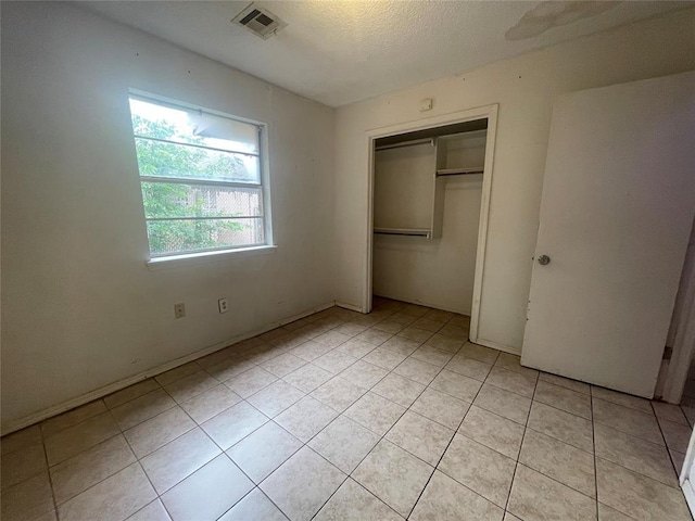 5333 Coble St, Oklahoma City, OK 73135 - unfurnished bedroom with light tile patterned floors, a closet, and a textured ceiling