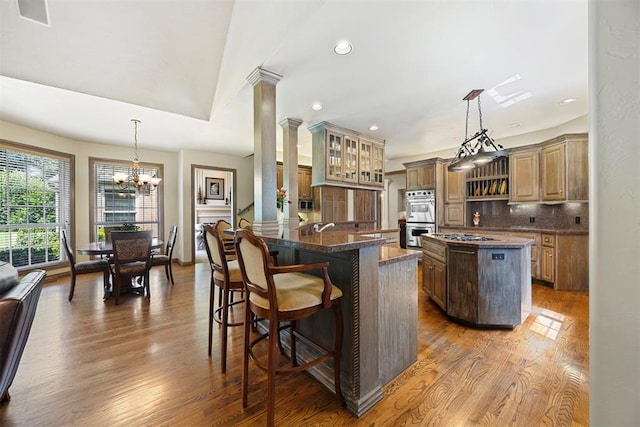 1608 Mulholland Dr, Edmond, OK 73003 - kitchen featuring a center island, stainless steel appliances, dark wood-type flooring, backsplash, and a chandelier