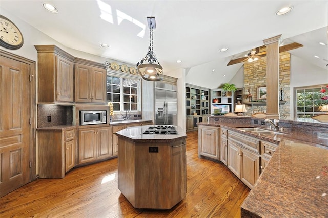 1608 Mulholland Dr, Edmond, OK 73003 - kitchen with built in appliances, decorative columns, light wood-type flooring, a kitchen island, and lofted ceiling