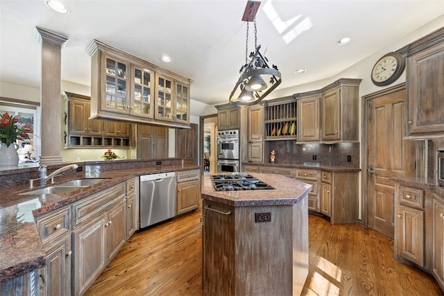 1608 Mulholland Dr, Edmond, OK 73003 - kitchen with appliances with stainless steel finishes, a center island, light wood-style floors, glass insert cabinets, and decorative backsplash