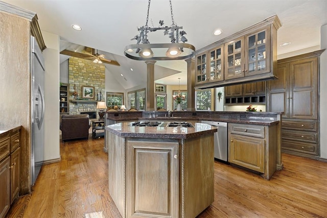 1608 Mulholland Dr, Edmond, OK 73003 - kitchen featuring appliances with stainless steel finishes, a ceiling fan, a peninsula, a fireplace, and a kitchen island