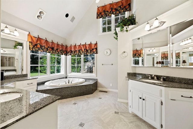 1608 Mulholland Dr, Edmond, OK 73003 - full bathroom with two vanities, high vaulted ceiling, a garden tub, and marble finish floors