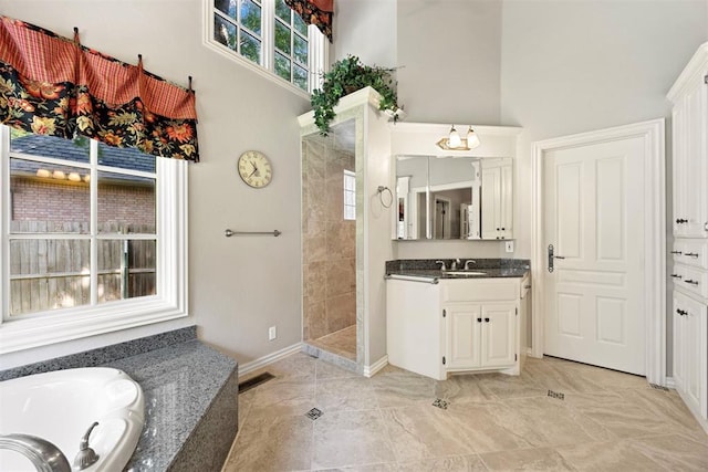 1608 Mulholland Dr, Edmond, OK 73003 - bathroom with a towering ceiling, vanity, a garden tub, and a tile shower