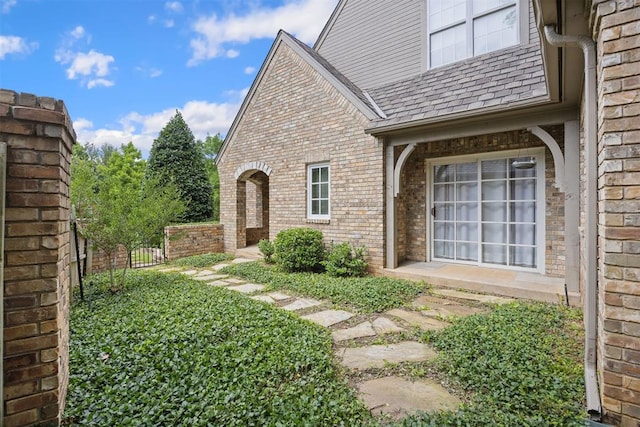 1608 Mulholland Dr, Edmond, OK 73003 - doorway to property featuring brick siding and roof with shingles