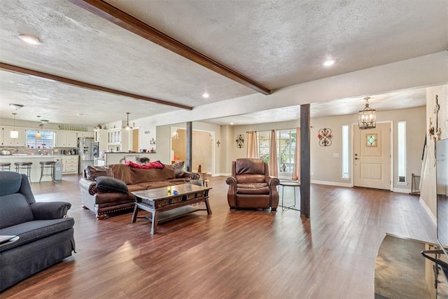 11900 Surrey Ln, Yukon, OK 73099 - living room with a textured ceiling, wood finished floors, beamed ceiling, healthy amount of natural light, and recessed lighting