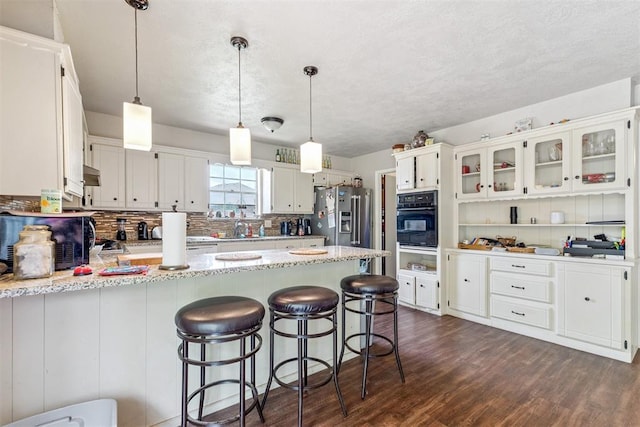 11900 Surrey Ln, Yukon, OK 73099 - kitchen with oven, a peninsula, dark wood finished floors, stainless steel refrigerator with ice dispenser, and backsplash