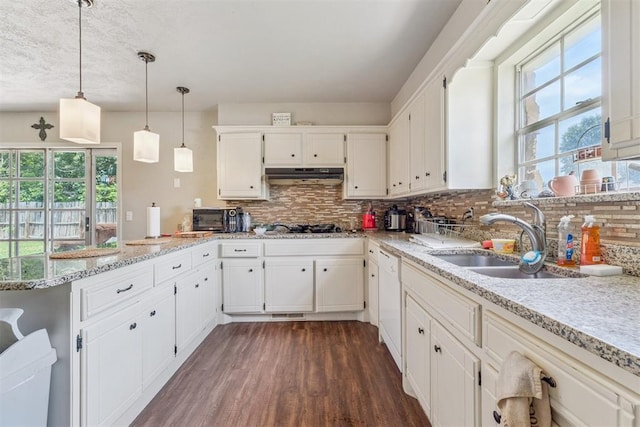11900 Surrey Ln, Yukon, OK 73099 - kitchen featuring a peninsula, plenty of natural light, tasteful backsplash, and dark wood-style flooring
