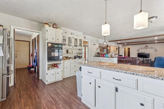 11900 Surrey Ln, Yukon, OK 73099 - kitchen featuring black oven, freestanding refrigerator, dark wood-style flooring, and white cabinetry