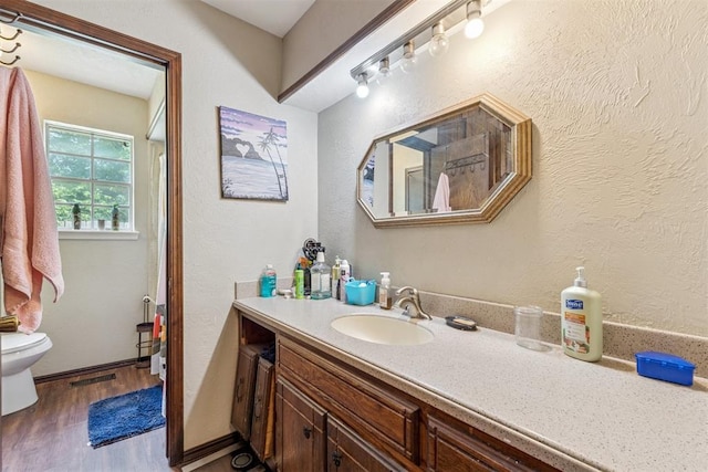 11900 Surrey Ln, Yukon, OK 73099 - full bathroom with wood finished floors, vanity, and a textured wall